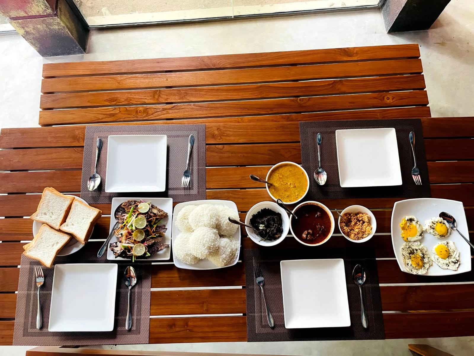 Top-down Sri Lankan breakfast spread with string hoppers, curries and eggs