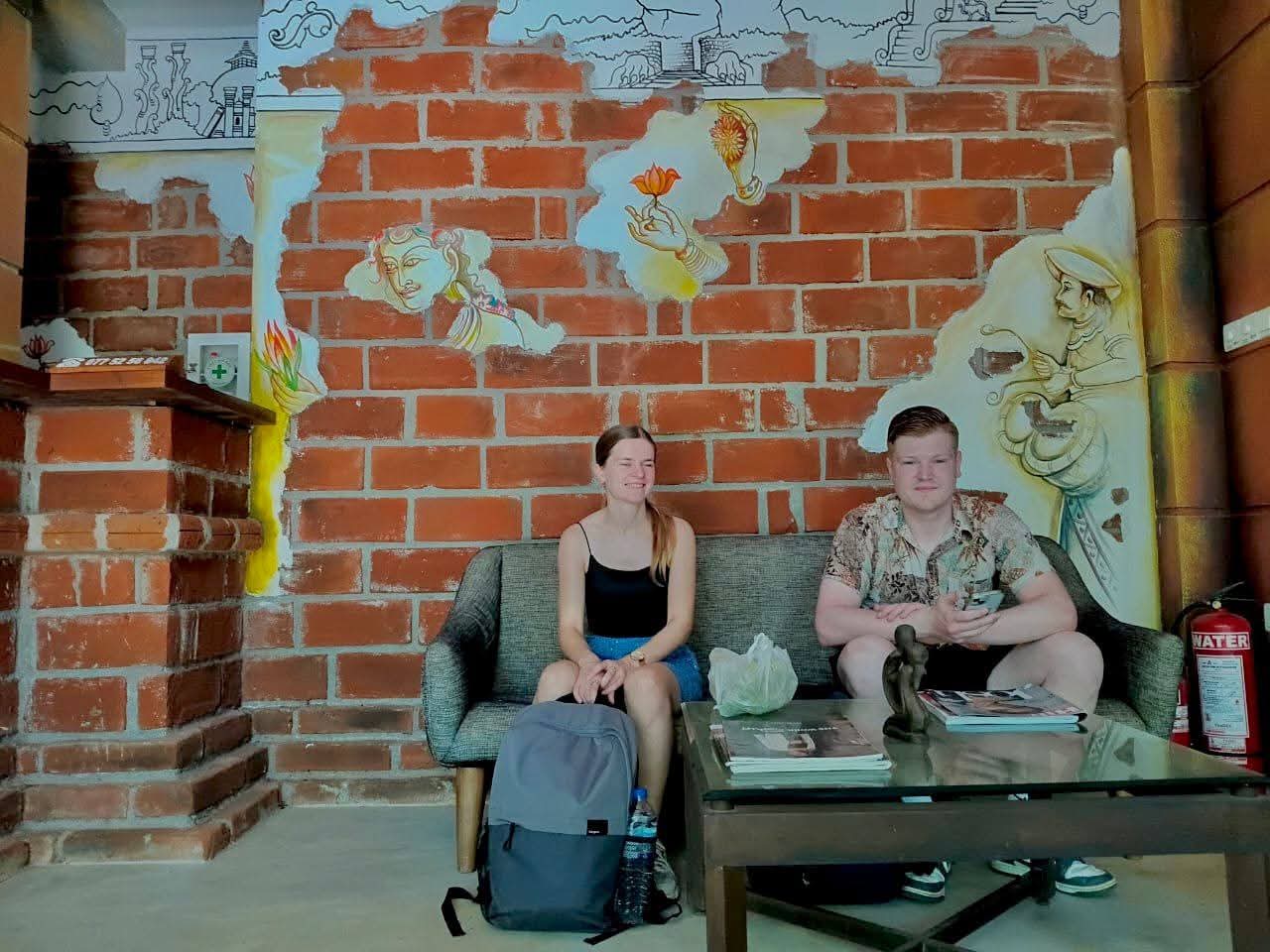 Guests in the lounge by brick mural wall