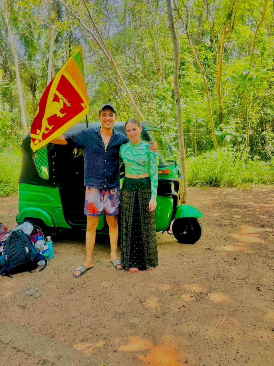 Travellers with a tuk-tuk and Sri Lankan flag in the forest