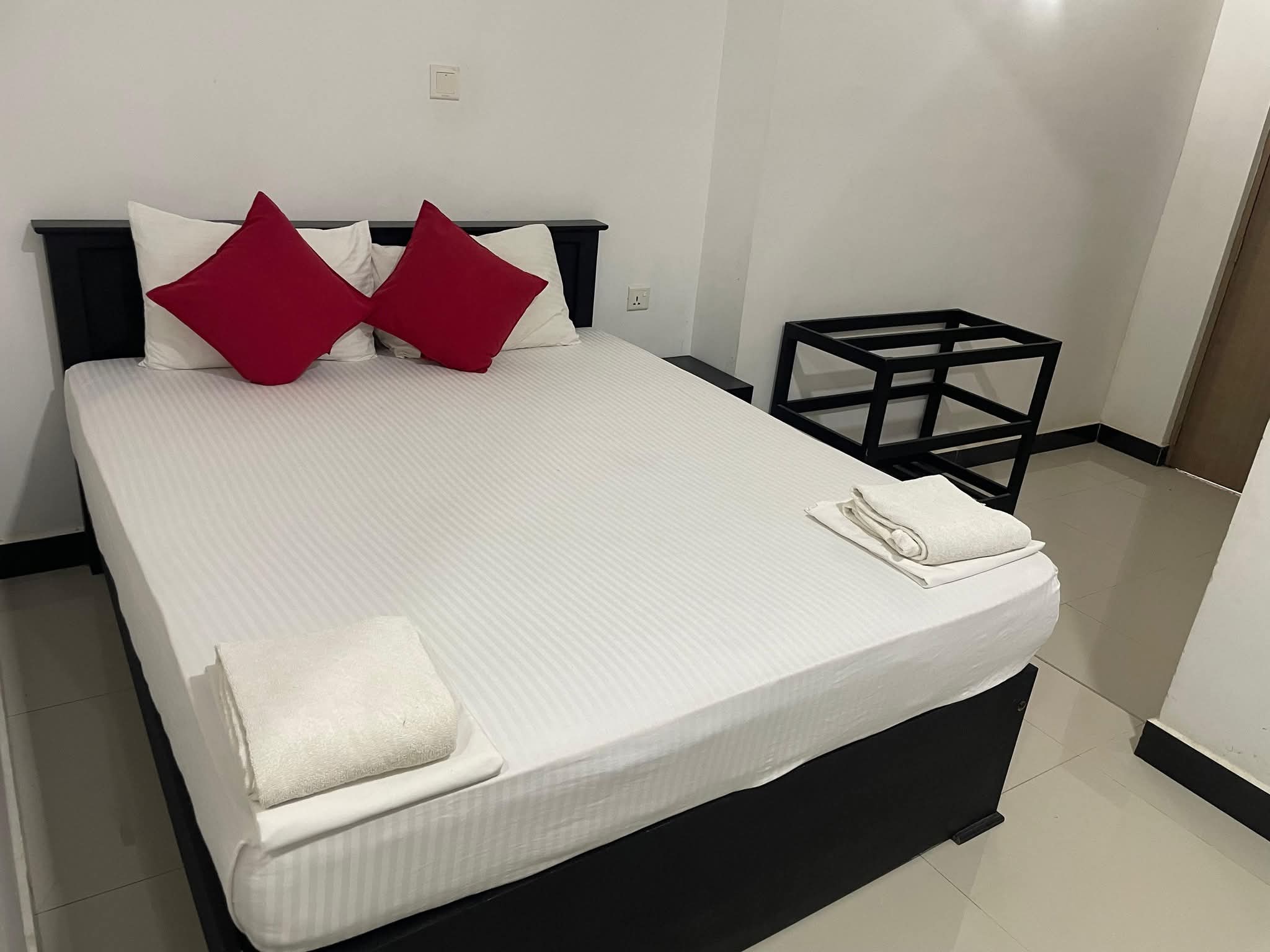 Comfortable double room with crisp white bedding and red cushions